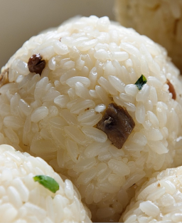 传统的日本三角饭团食谱，手工捏制的米饭球，内馅可为鱼肉、梅干或腌制蔬菜。作为日本大众料理的流动象征，它兼具简单、正宗与便携性。