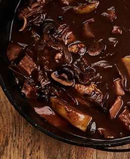 Recette de  Coq au Vin de Chanturgue, plat traditionnel auvergnat fondant, lié au sang et parfumé au marc