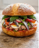 Recette du pan bagnat niçois complet : pain rond à l'huile d'olive garni de salade niçoise traditionnelle